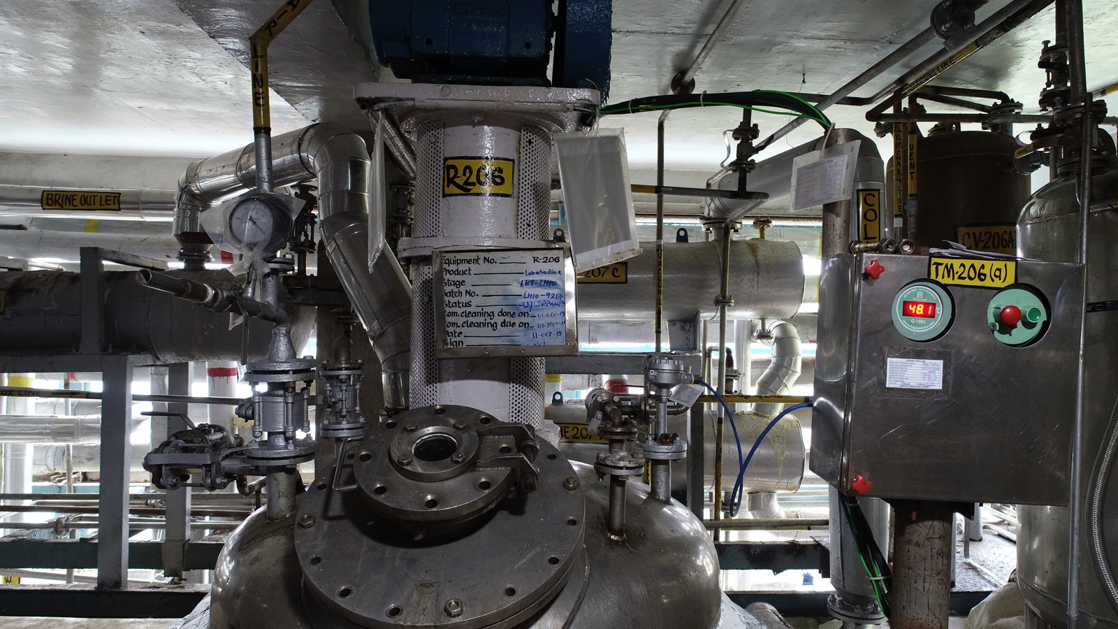 Reactor vessel with instrumentation and batch status board on a Morepen plant floor